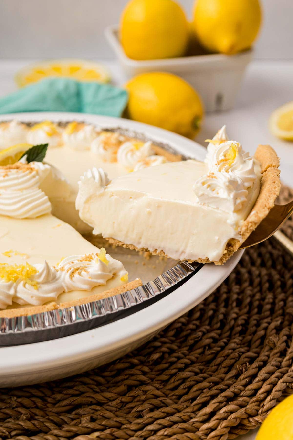 A spatula removing a slice of lemon cheesecake pie.