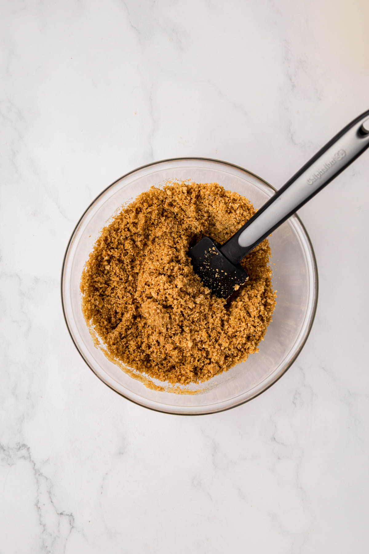 Graham cracker crumbs, sugar and butter mixed in a bowl.