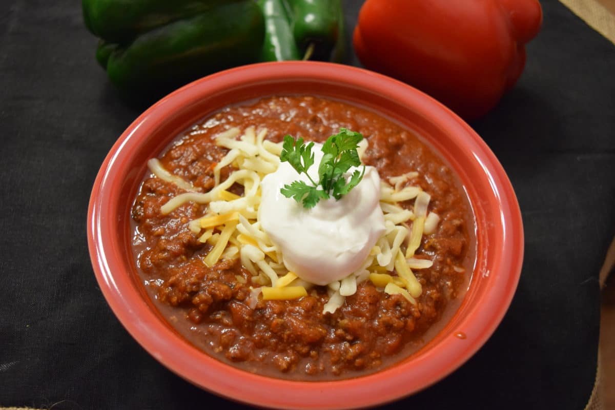 an overhead view of this no bean chili topped with shredded cheese and sour cream