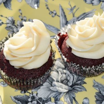 two homemade red velvet cupcakes with cream cheese frosting