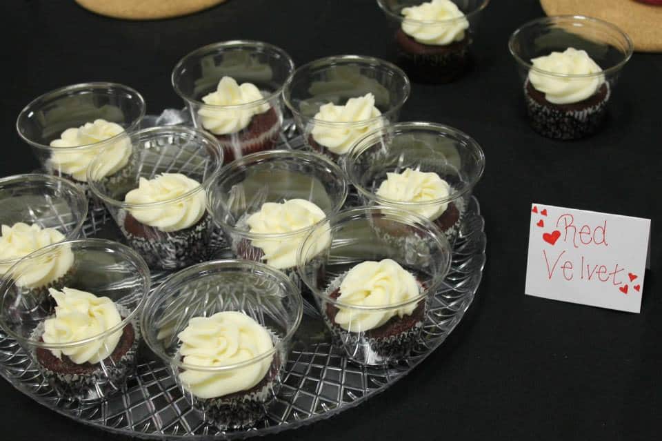 Cupcakes in a clear cup on a tray.