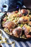 Chicken thighs with cajun style dirty rice in a cast iron skillet