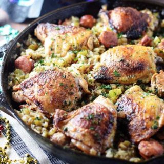 Chicken thighs with cajun style dirty rice in a cast iron skillet