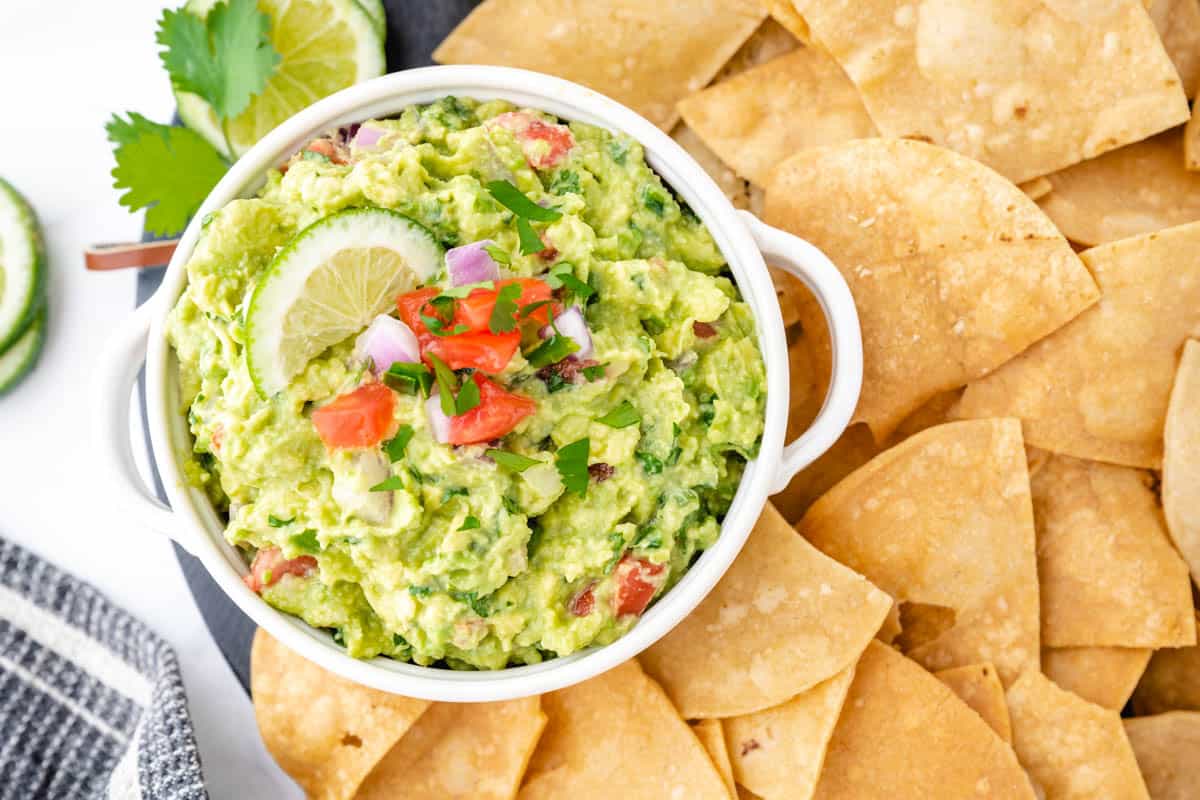 Bowl of guacamole on Mexican comal decorated with tortilla chips