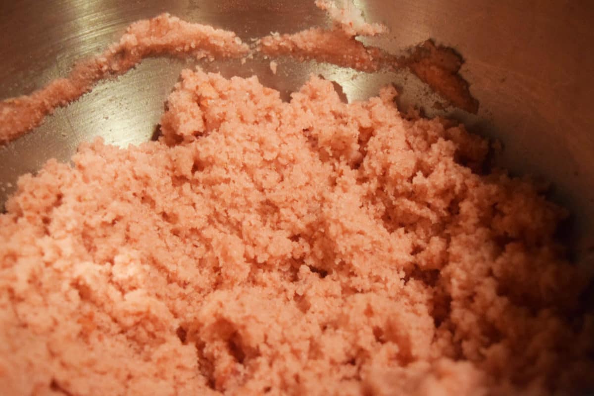 a closeup of this pink strawberry sugar scrub inside of a stand mixer\'s mixing bowl