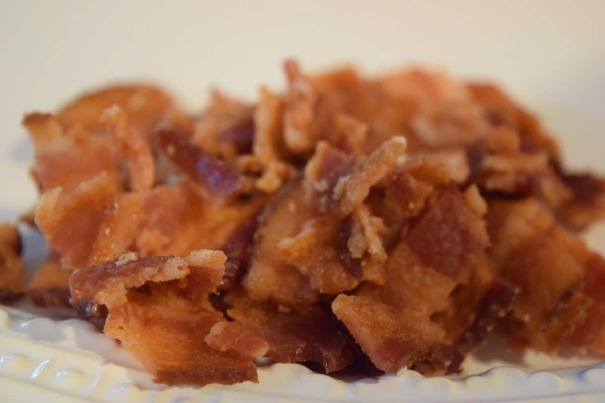 crispy chopped fried bacon draining on a paper towel