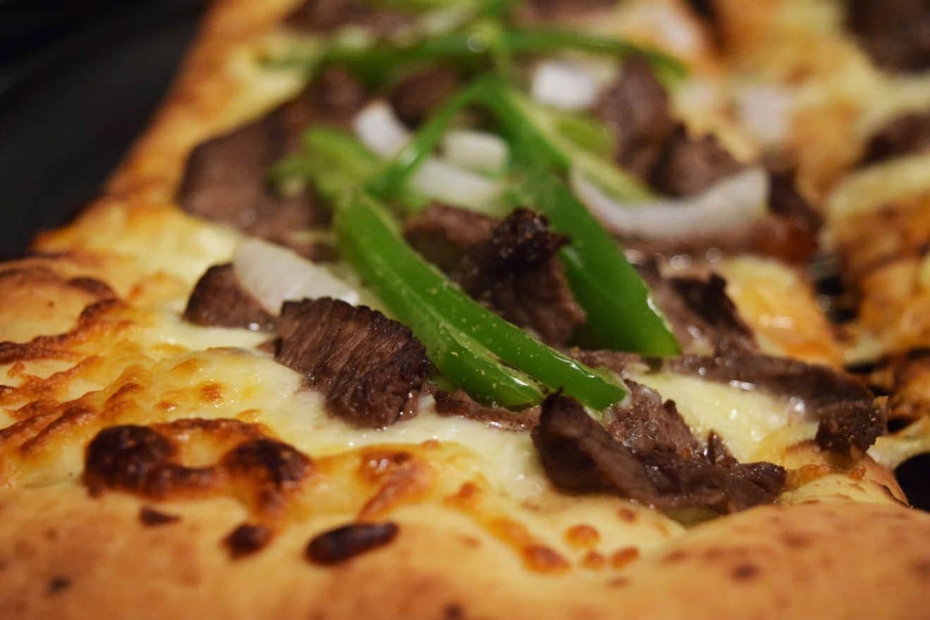 a closeup of this philly cheese steak pizza 