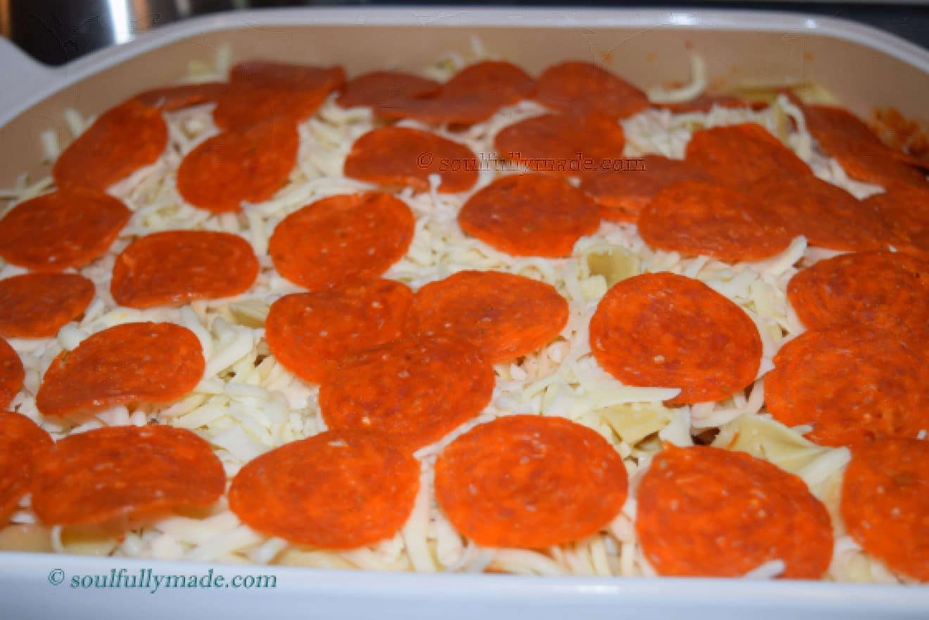 a closeup of this pizza noodle bake topped with pepperonis before baking in the oven