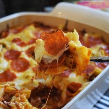 a spoon scooping up a serving of this pizza noodle bake