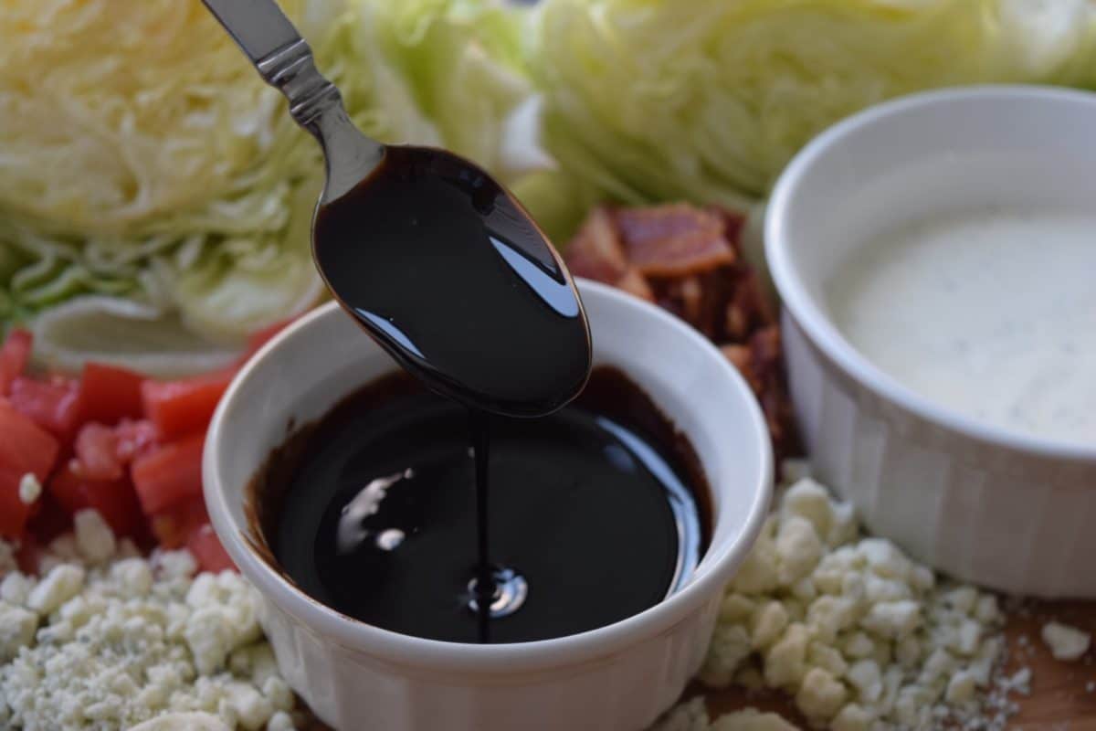 a small white bowl filled with this sweet balsamic vinegar glaze and a spoon dipped in it