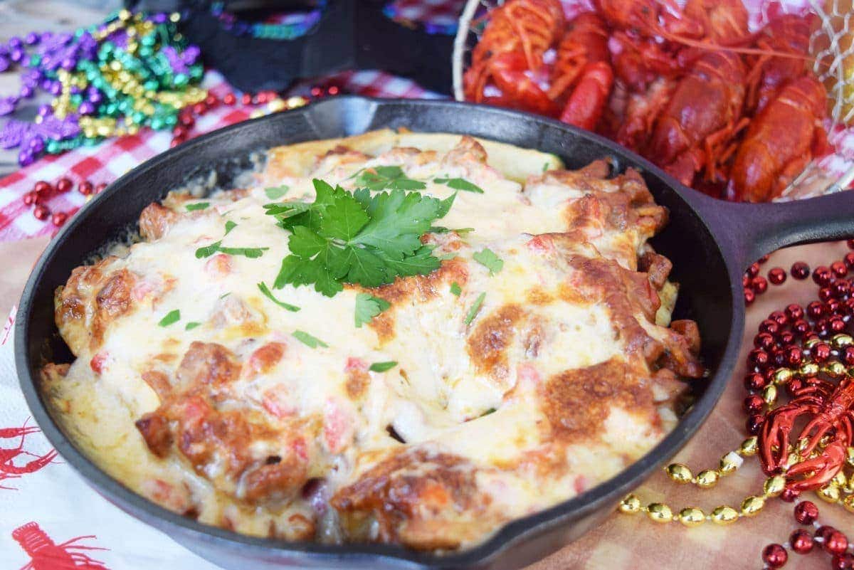a side view of a black cast iron skillet filled with this andouille and crawfish pimento cheese fries recipe