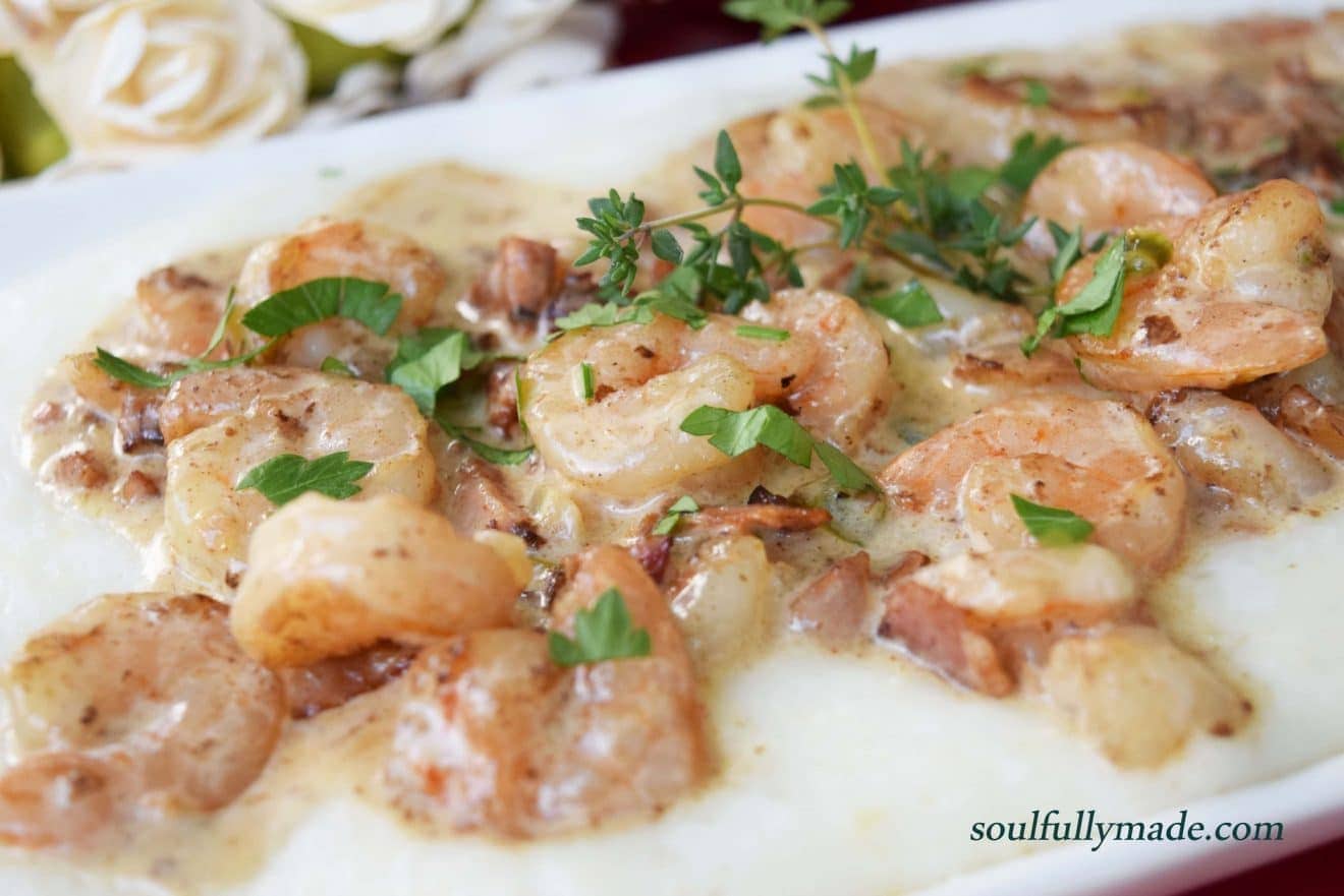 a closeup of this shrimp and grits with andouille cream sauce recipe on a white plate