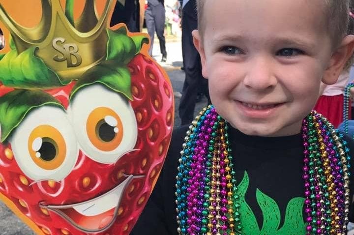 a child smiling at the strawberry festival parade