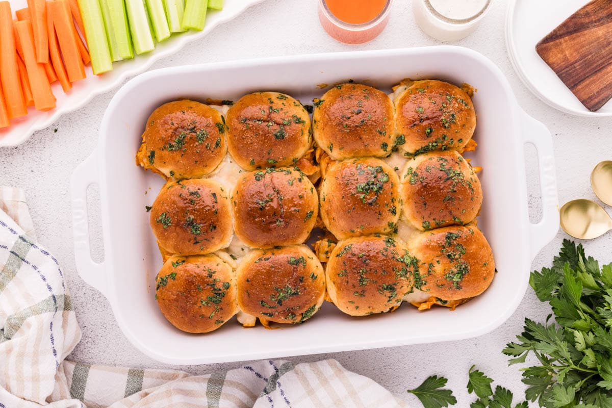 Buffalo chicken sliders in a white baking dish.