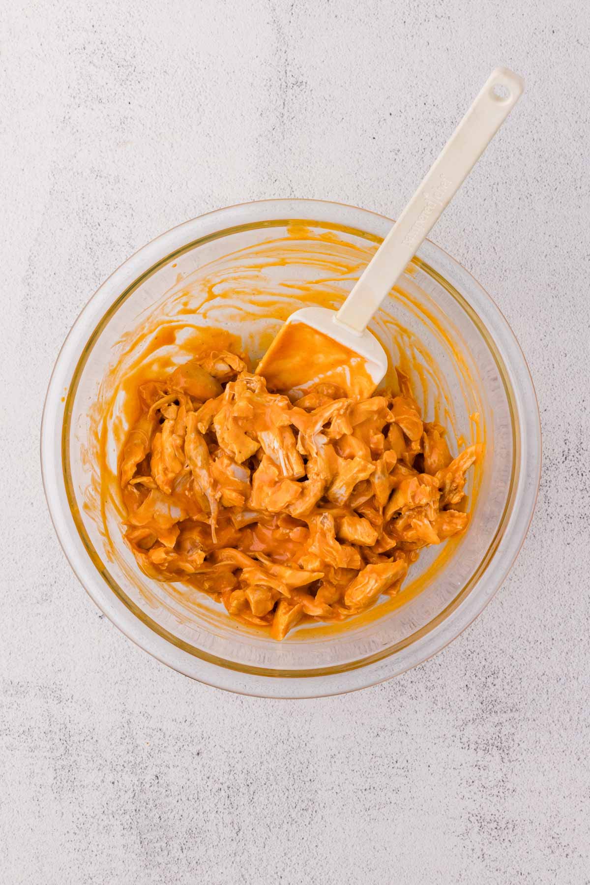 Shredded Chicken, buffalo sauce, ranch dressing, garlic powder, and onion powder combined in a bowl.