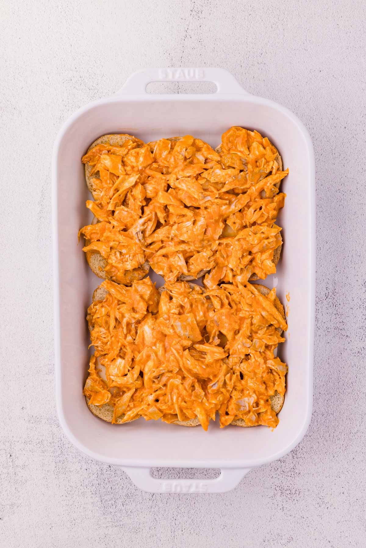 Buffalo chicken added to the cheese on top of slider buns.