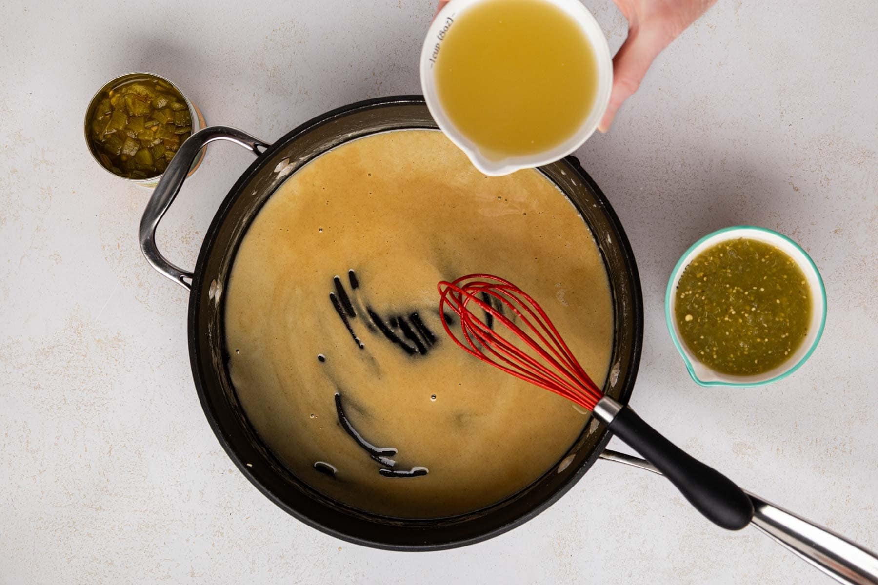 Pouring chicken stock into flour mixture.