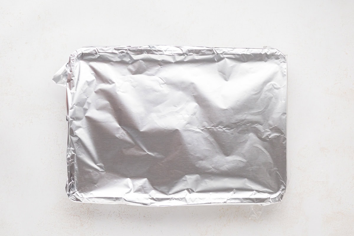 Foil placed on top of casserole to completely cover it.