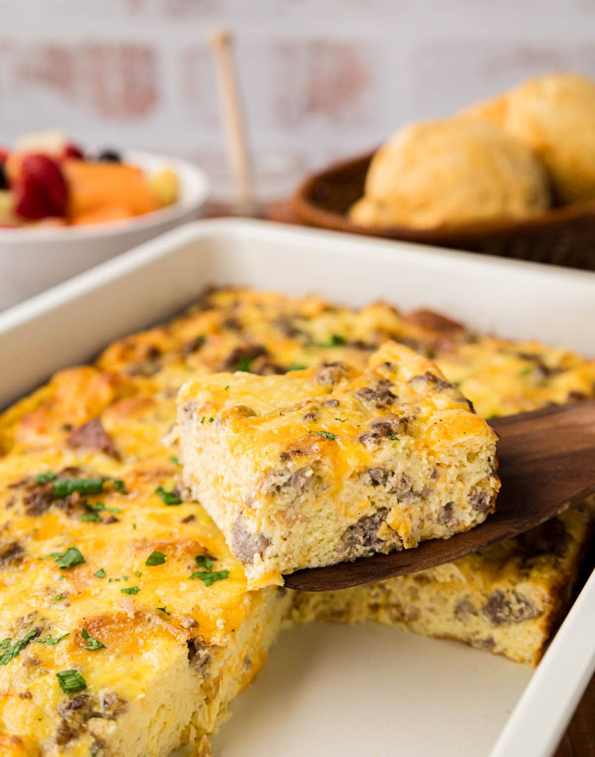 Removing a slice of the breakfast casserole with a spatula from the casserole dish.