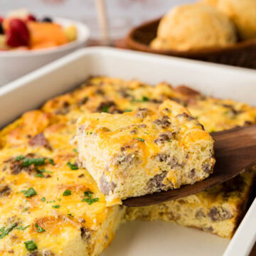 Removing a slice of the breakfast casserole with a spatula from the casserole dish.