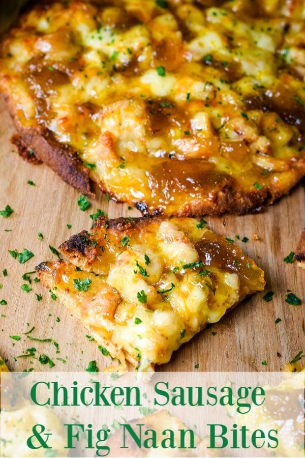 A closeup of a slice of this sausage and fig naan pizza topped with chopped parsley on a wooden cutting board