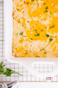 Pin 4 Cheesy Au Gratin Potatoes Recipe in a casserole dish on a wire cooling rack.