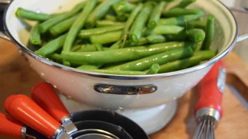 Fresh Snapped Green Beans rinsed with water in a while colander.