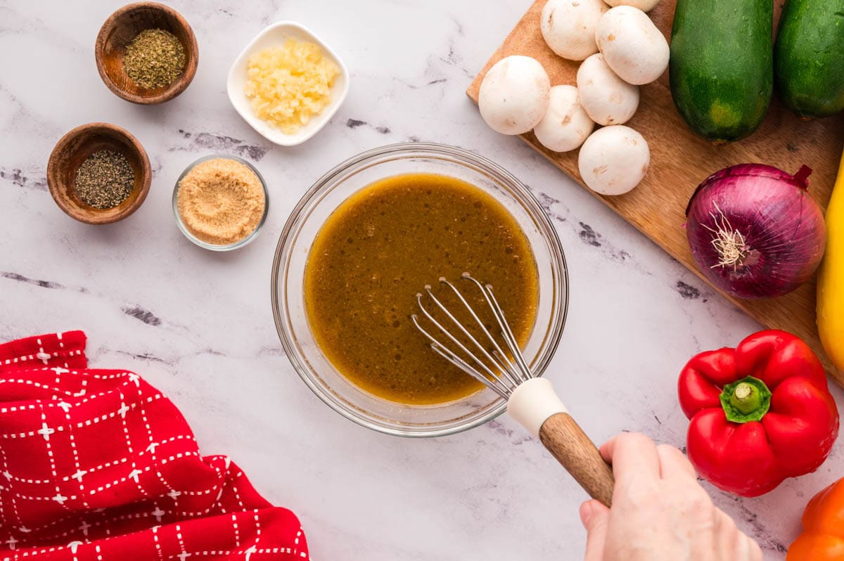 Whisking the marinade ingredients together in a bowl.