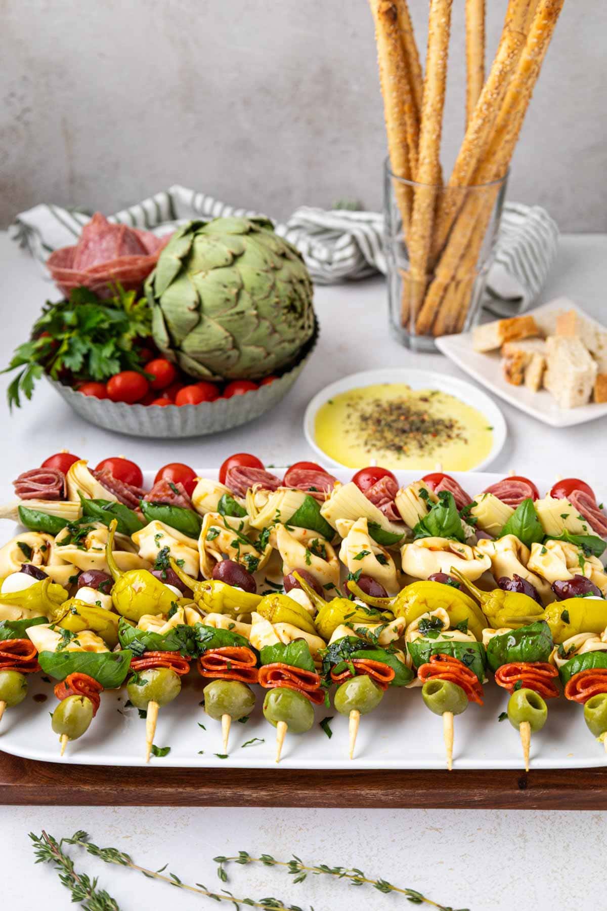 Skewers on a platter with a beautiful Italian tablescape in the background.