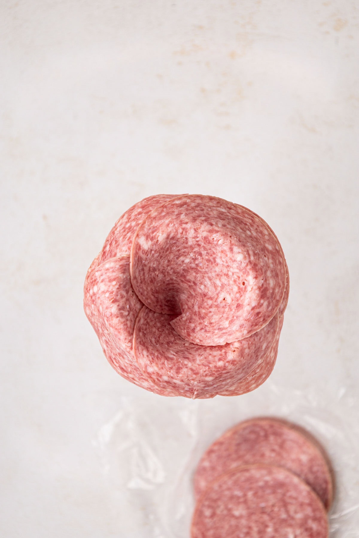 Salami slices added to a glass rim to make the rose shape.