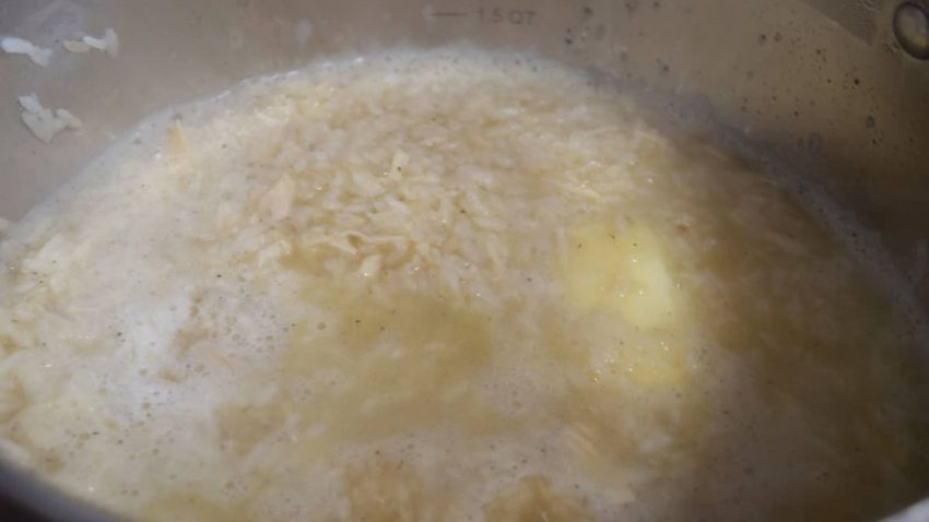 a closeup of the uncooked rice and sautéed chicken ready to be boiled for this chicken and rice recipe