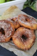 a closeup of these fried green apple slices that resemble donuts dusted in cinnamon sugar