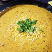 A large cast iron skillet filled with this homemade skillet beef queso dip cheese dip recipe as a game day appetizer
