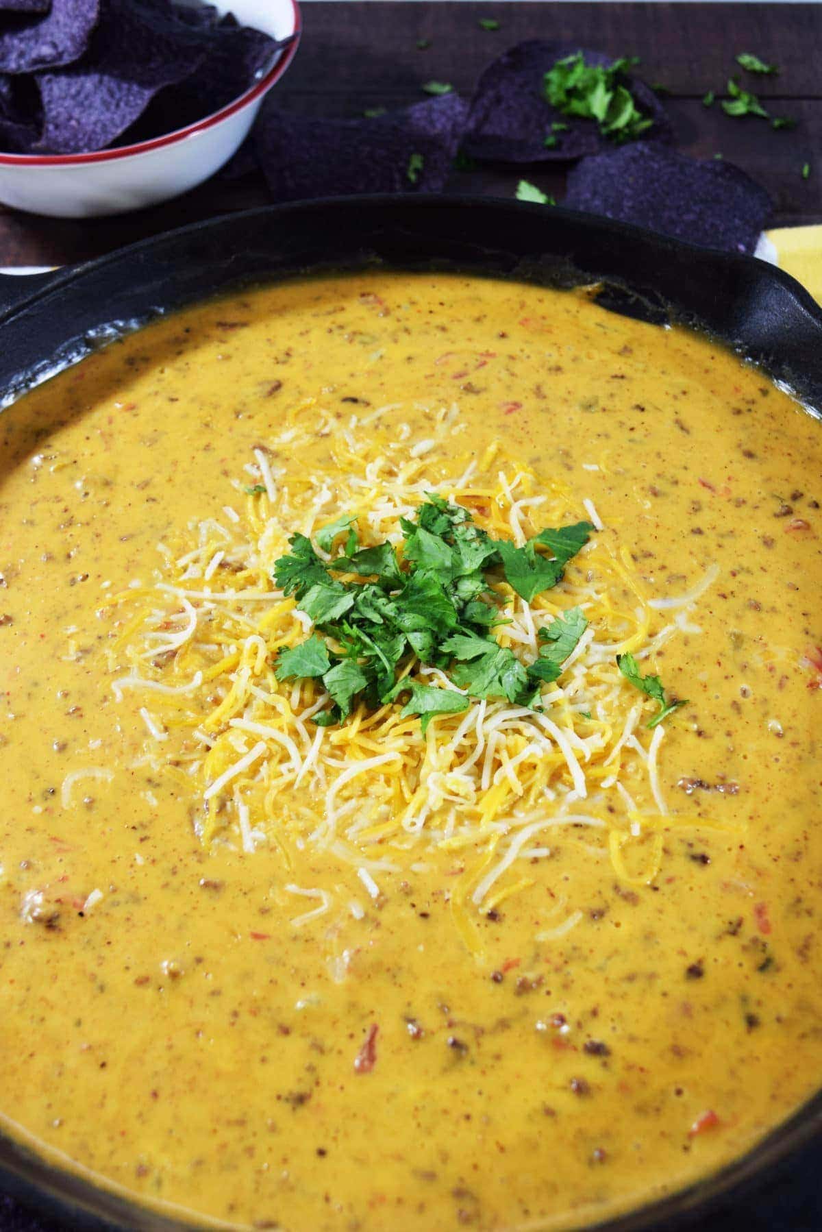 A large cast iron skillet filled with this homemade skillet beef queso dip cheese dip recipe as a game day appetizer