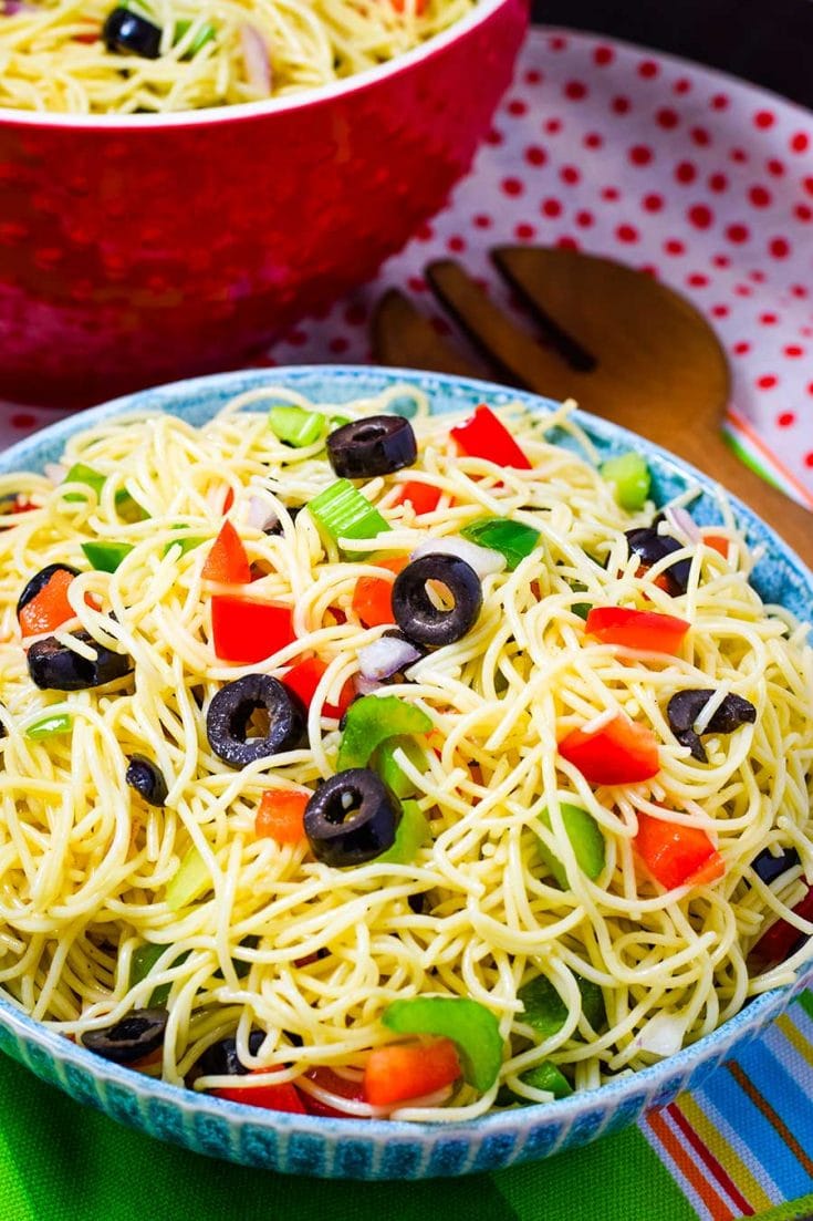 A bowl filled with Shelly\'s Spaghetti Pasta Salad with black olives and chopped bell peppers