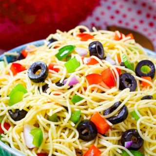 A bowl filled with Shelly's Spaghetti Pasta Salad with black olives and chopped bell peppers