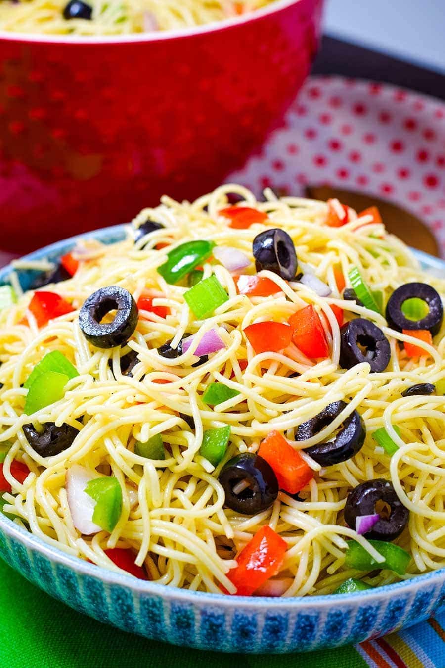 A bowl filled with Shelly's Spaghetti Pasta Salad with black olives and chopped bell peppers