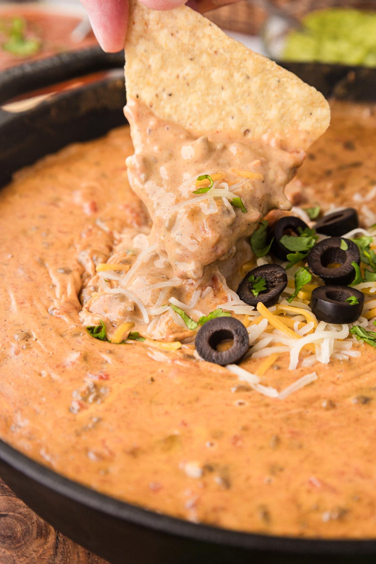 Dipping a tortilla chip into  queso beef dip.