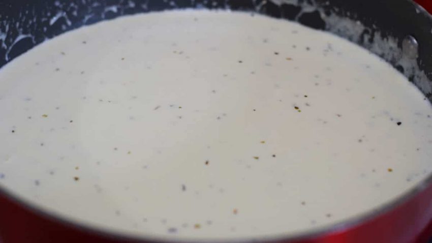 a black skillet filled with this homemade alfredo sauce