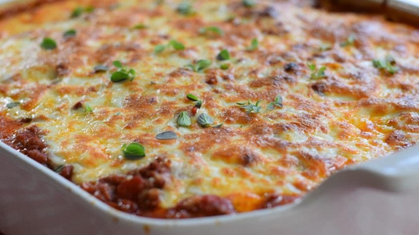 a closeup of this ultimate baked spaghetti fresh from the oven with melted cheese and chopped parsley