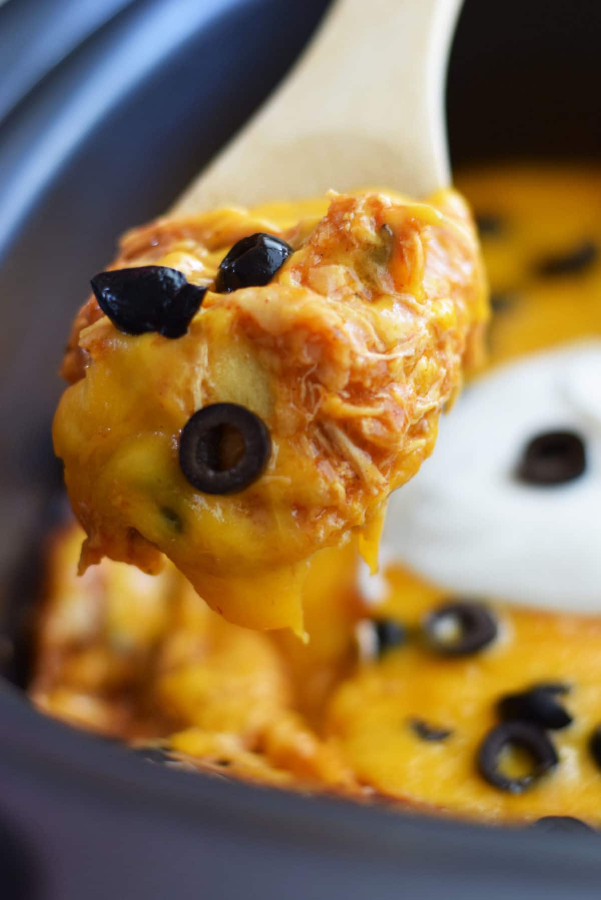 a closeup of a spoonful of this crock pot chicken enchilada casserole made in the slow cooker
