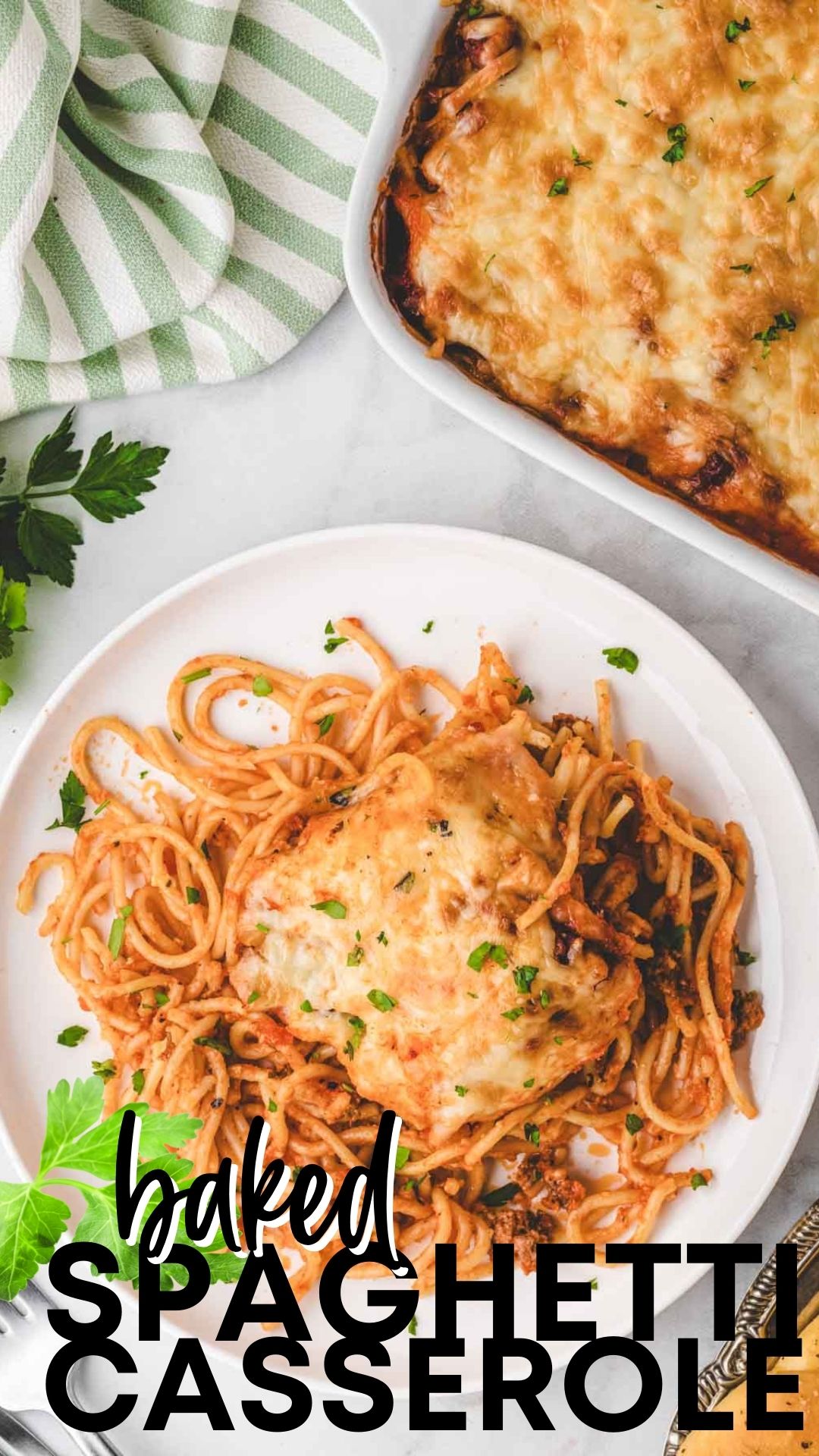 Closeup overhead shot of a white plate filled with baked spaghetti casserole topped with cheese.