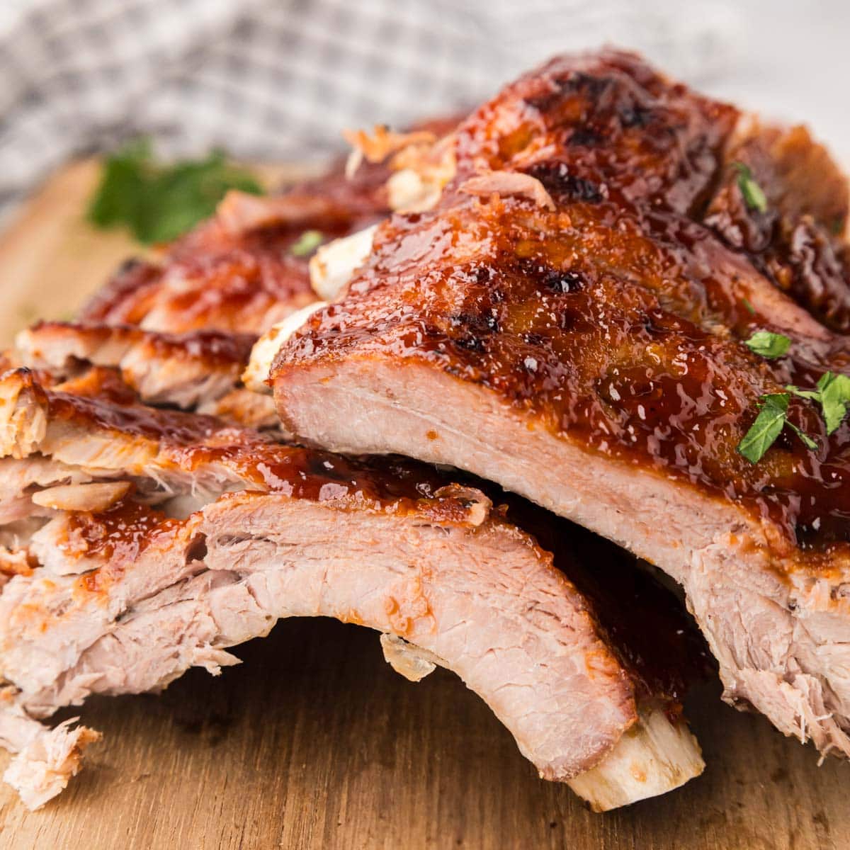 Cut BBQ baby back ribs on a wooden board.