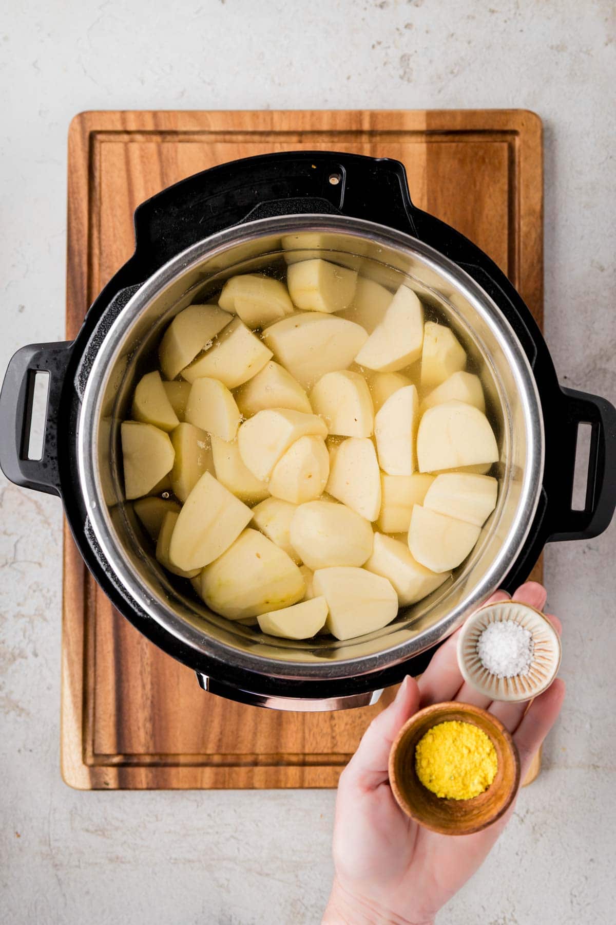 Instant pot filled with water and peeled potatoes.