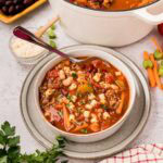 A bowl of copycat Olive Garden pasta fagioli soup with the soup pot and a bowl of ditalini pasta in the background.