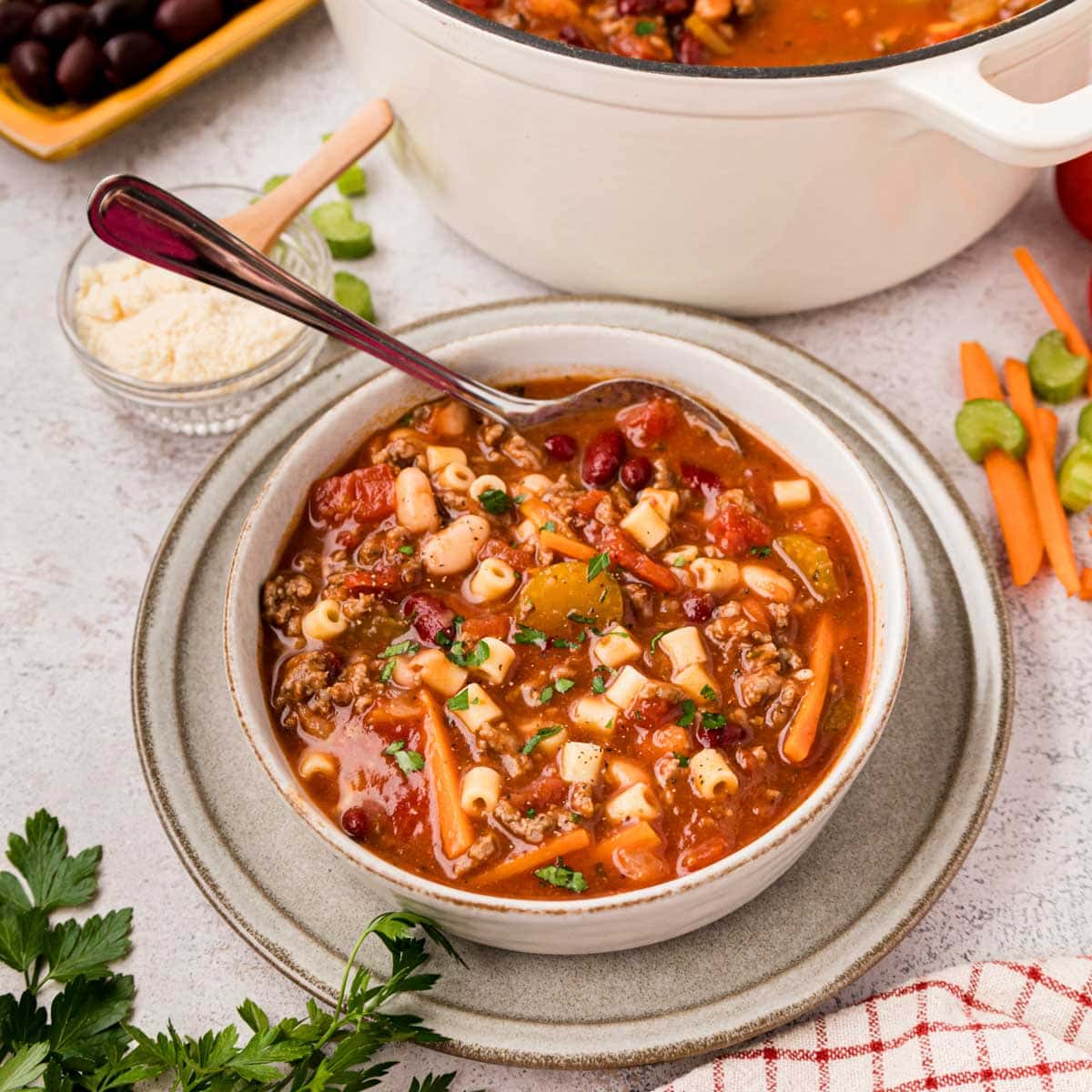 A bowl of copycat Olive Garden pasta fagioli soup with the soup pot and a bowl of ditalini pasta in the background.