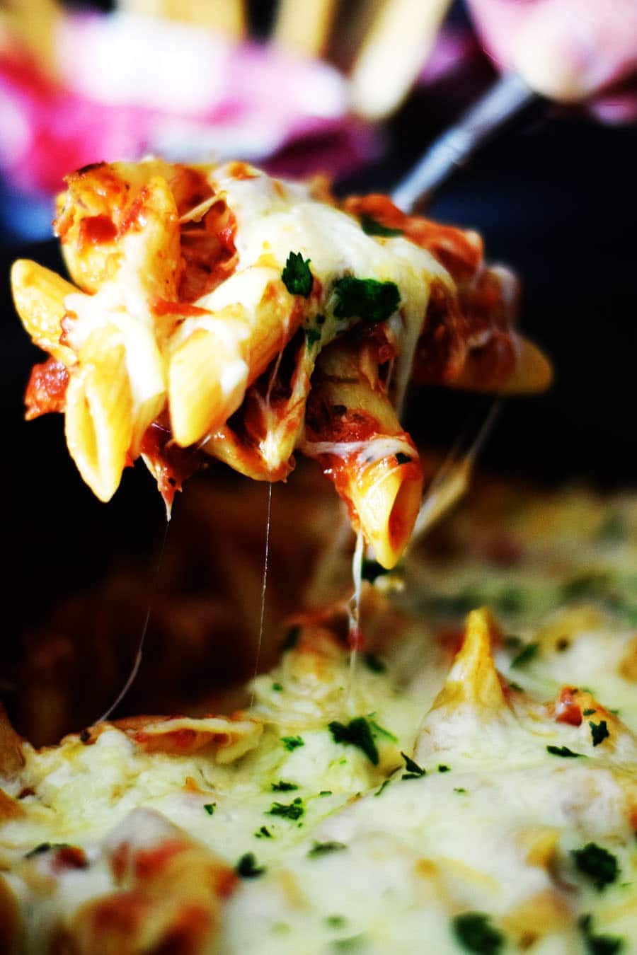 a closeup of a forkful of this crock pot chicken parmesan penne pasta