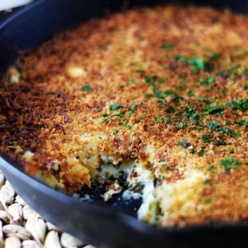 A closeup of this collard greens au gratin recipe in a black cast iron skillet