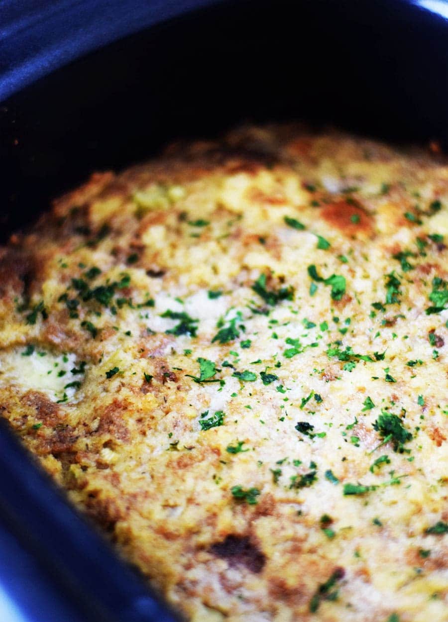 a closeup of the cooked cornbread dressing inside of the slow cooker