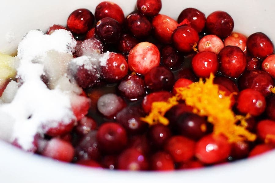 a bowl filled with the ingredients needed to make this homemade cranberry sauce recipe